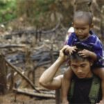 Free Burma Ranger carrying a displaced child after the Burma Army burned his village (photo courtesy FBR)