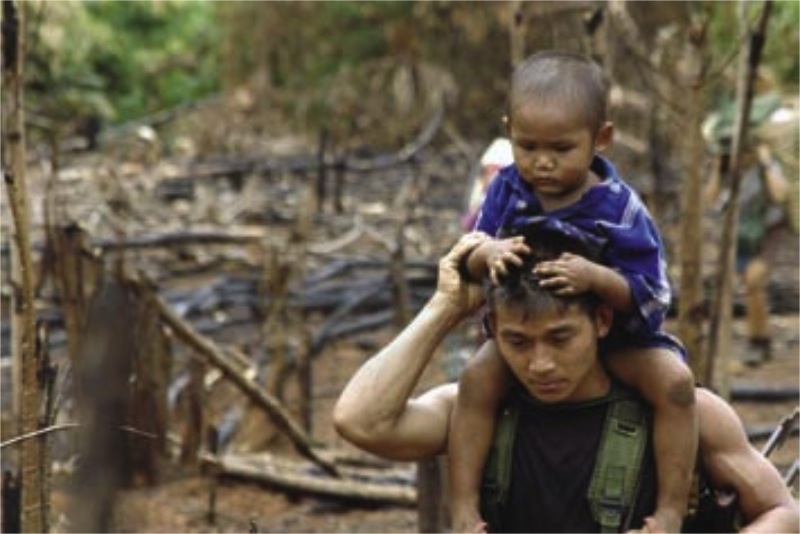 Free Burma Ranger carrying a displaced child after the Burma Army burned his village (photo courtesy FBR)